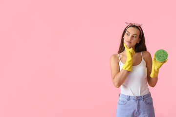 Thoughtful young woman with sponge on color background