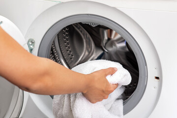 Woman takes white clothes out of washing machine
