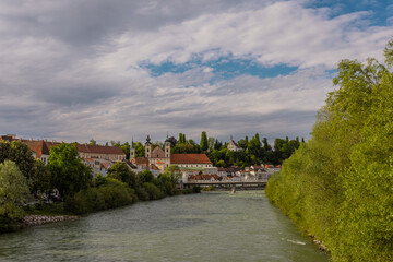 Fototapeta na wymiar Beautiful panorama of the city of Steyr in upper Austria, rising above the river of Enns on the green river banks.