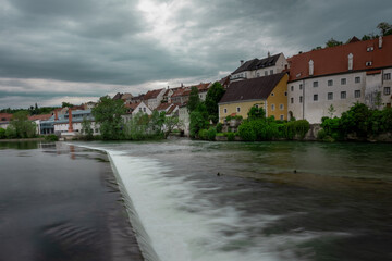 Beautiful panorama of the city of Steyr in upper Austria, rising above the river of Enns on the green river banks. River and small rapids  in the foreground