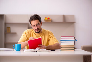 Young male student preparing for exams at home