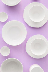Set of stylish dinnerware on purple background