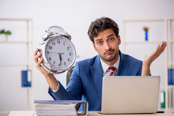 Young male employee in time management concept