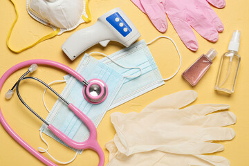 Medical equipment, masks, antiseptic and gloves on yellow background