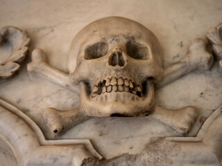 Fototapeta na wymiar Stone skull with crossbones, symbol of death