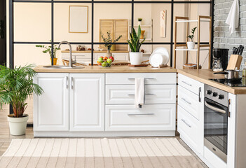 Interior of modern kitchen with counters and sink
