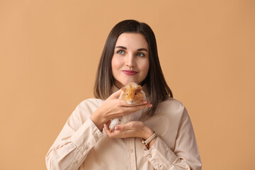 Beautiful young woman with cute guinea pig on color background