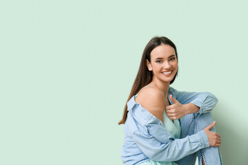 Obraz premium Young woman with applied medical patch showing thumb-up on color background