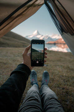 hand with smartphone while camping in the swiss alsp
