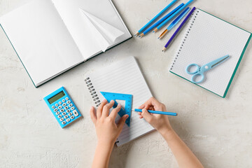 Child drawing with ruler and pencil on light background