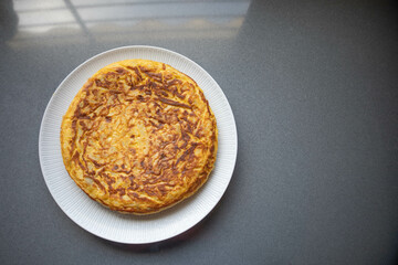 Spanish omelette with potato and onion, in a white plate ready to be taken to a picnic