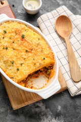 Baking dish with tasty Shepherd's pie on dark background, closeup