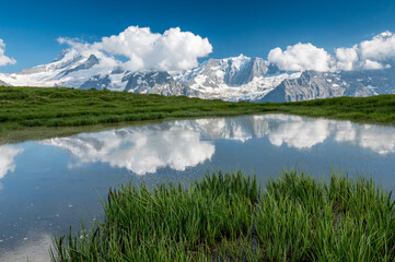 alpine pond with reflection of mountains above grindelwald