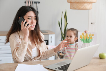 Little daughter keeping mother from her work at home - obrazy, fototapety, plakaty