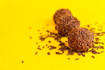 Brigadeiros lined up on a yellow background