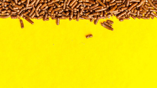 Chocolate sprinkles on yellow background with copy space. Ingredient of Brazilian Brigadeiro.