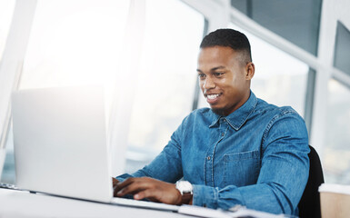 Work hard, but always work smarter. Shot of a young businessman working on a laptop at his desk in...