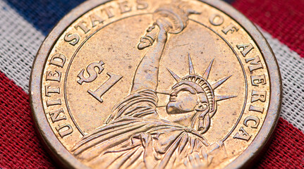 One dollar coin. US American flag background. Money United States of America. Statue of Liberty. American cash. Metallic golden - copper circle coin. Financial marketplaces. High quality macro photo.