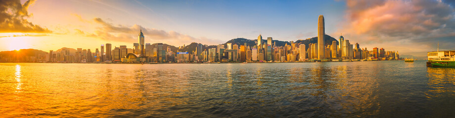 Fototapeta na wymiar Sunrise over Hong Kong Island and the highrise buildings as seen from across the harbor at Tsim Sha Tsui on the Kowloon side. 