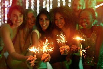 Obraz na płótnie Canvas Good friends, good times. Shot of a group of girlfriends having fun with sparklers on a night out.