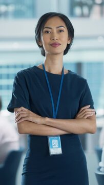 Vertical Screen: Businesswoman in Stylish Dress Crossing Arms, Standing in Modern Office with Diverse Working on Financial, Business and Marketing Projects. Portrait of Beautiful Asian Manager.