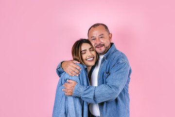 latin father and daughter in casual clothes in a copy space on pink background in Mexico Latin...