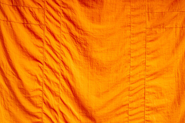 Full frame close up of an orange piece of fabric (cowl)