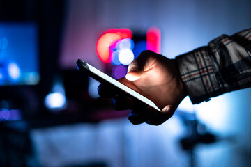 person holding smartphone and scrolling on web page at night