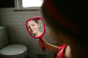 girl looks at reflection in mirror