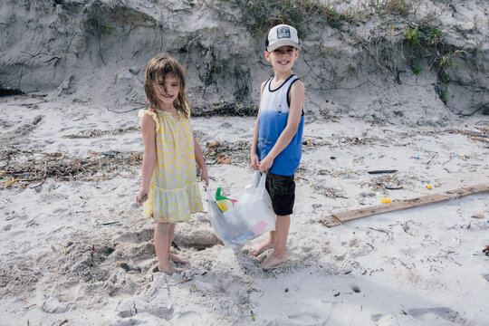 children up plastic trash from beach