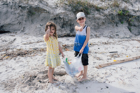 children up plastic trash from beach