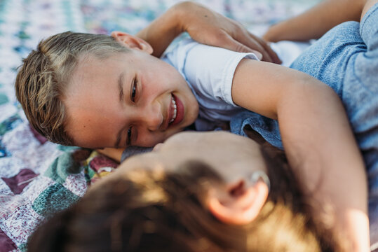 Mother and young son lying on blanket