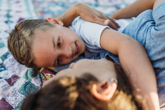 Tender mother and son on blanket outdoors