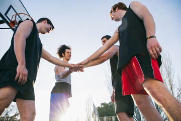 Men cheering while standing with hands together 