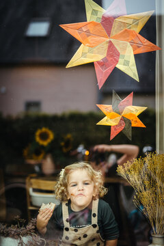 Window portrait of girl with waldorf paper kite stars