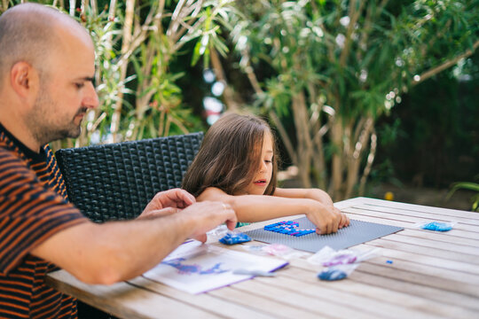 Dad with daughter composing game pieces