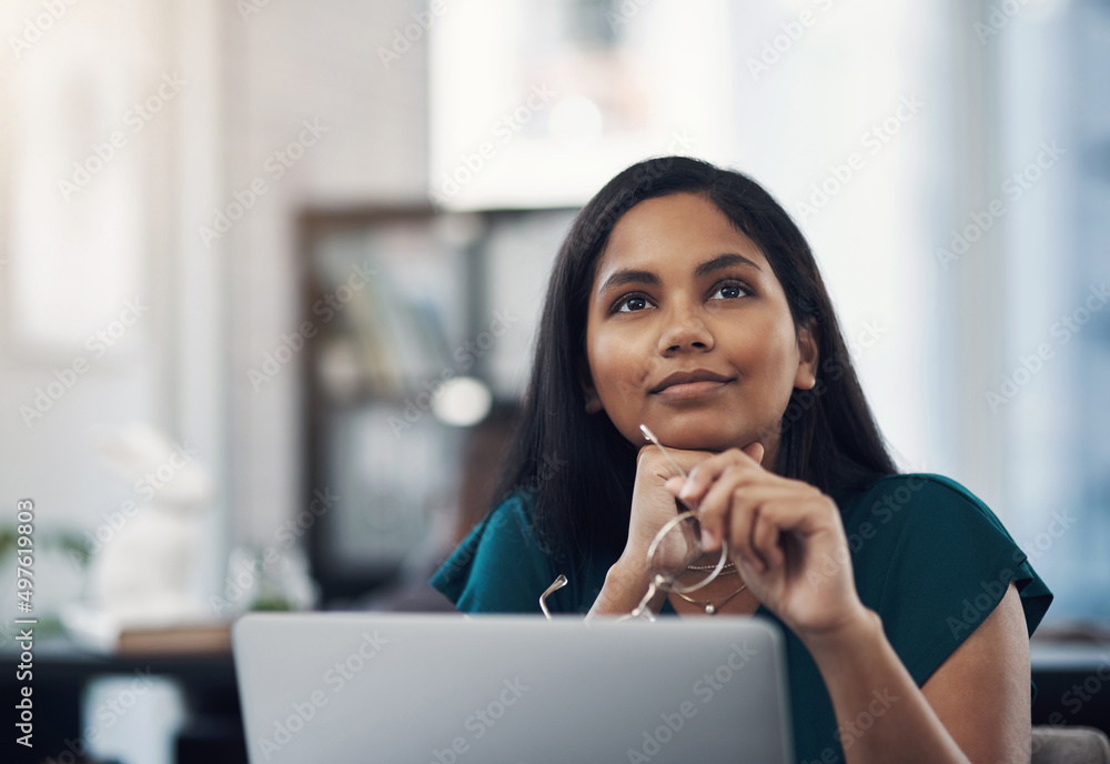 Poster dreams are our realities in waiting. shot of a young businesswoman looking thoughtful while working 