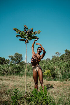 Portrait of expressive male dancer in nature with tree shadows 