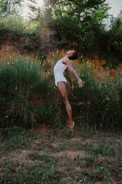 Portrait of expressive male dancer in nature jumping and moving