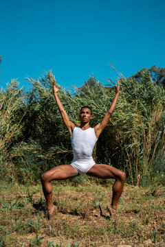 Portrait of expressive male dancer in nature jumping and moving