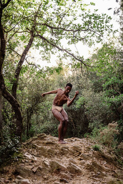Portrait of expressive male dancer in nature jumping and moving