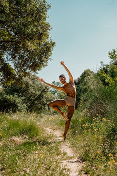 Portrait of expressive male dancer in nature jumping and moving