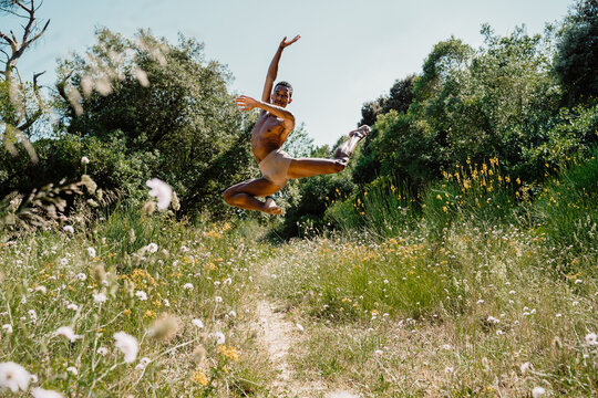 Portrait of expressive male dancer in nature jumping and moving