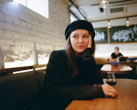 attractive woman in coat sitting in bar 