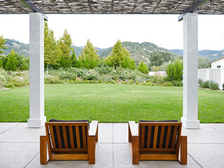 Two chairs on outdoor lounge patio area at resort with view of grass