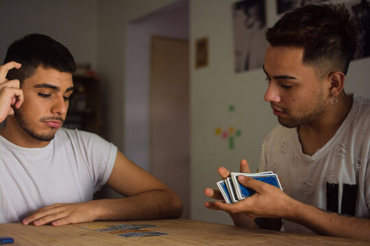 Latino Man Shuffling Cards On Table