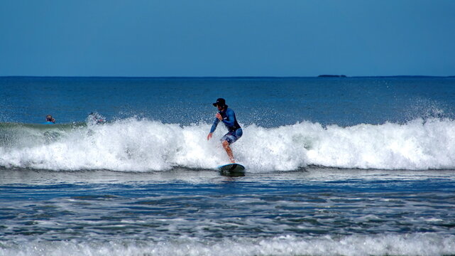 Man Surfing Off The Beach In Tamarindo, Guanacaste, Costa Rica