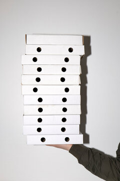 Stack of pizza boxes in hand