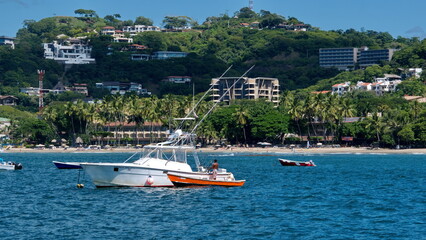 Fototapeta premium Boats moored in the bay off the beach in Tamarindo, Guanacaste, Costa Rica
