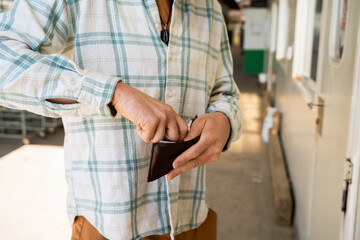Close-up image of man paying with wallet cash